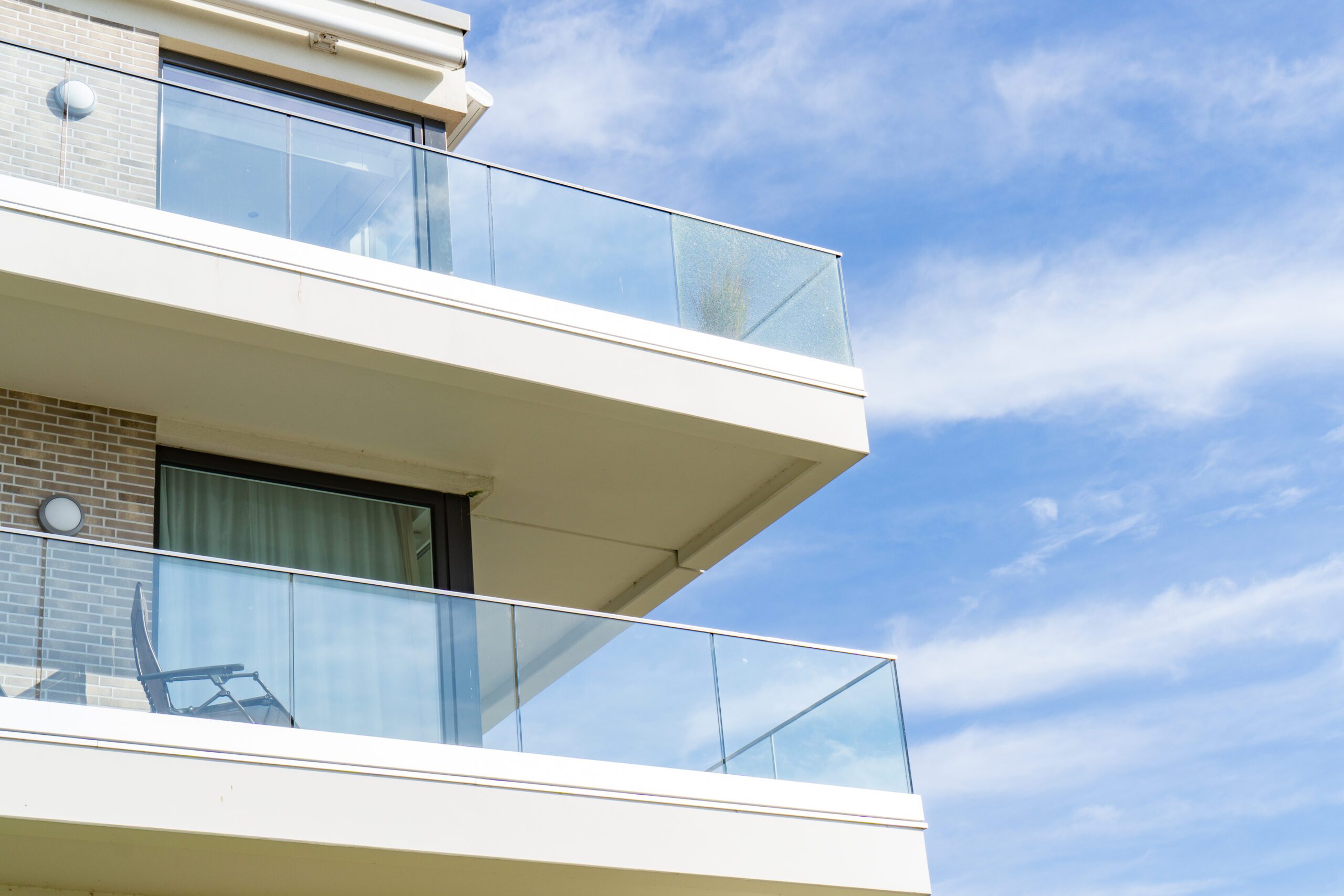 Brick home with glass railings on balcony